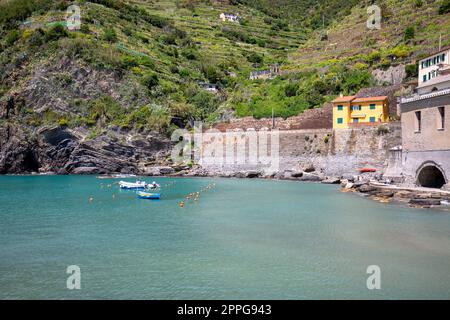 Vista sulla baia d'acqua con barche ormeggiate e tipiche case colorate nel piccolo villaggio, Riviera di Levante, Vernazza, cinque Terre, Italia Foto Stock