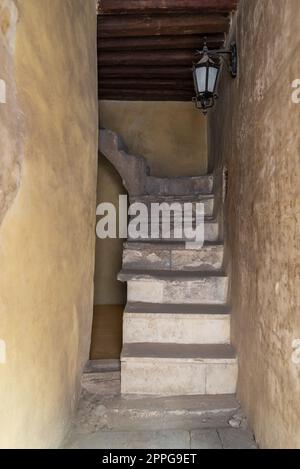 Foto del giorno di una vecchia scala in pietra stretta e del soffitto in legno Foto Stock