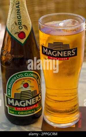 FUENGIROLA, SPAGNA - 10 OTTOBRE 2021: Bottiglia di sidro irlandese Magners, servita refrigerata in un bicchiere con il logo Magners Foto Stock