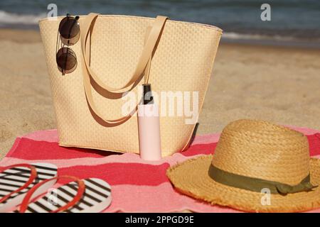 Cappello di paglia, borsa e altri articoli da spiaggia sulla spiaggia sabbiosa Foto Stock