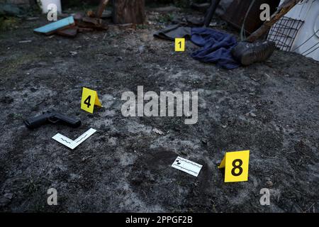 Prove con marcatore CSI giallo per la numerazione delle prove sul cortile residenziale di sera. Concetto investigativo sulla scena del crimine Foto Stock