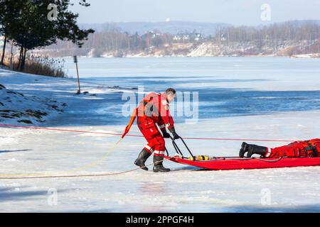 Esercitazioni di salvataggio dell'acqua in inverno su un lago ghiacciato in un buco, Cracovia, Polonia Foto Stock