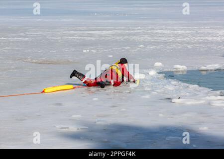 Esercitazioni di salvataggio dell'acqua in inverno su un lago ghiacciato in un buco, Cracovia, Polonia Foto Stock