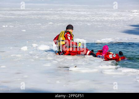 Esercitazioni di salvataggio dell'acqua in inverno su un lago ghiacciato in un buco, Cracovia, Polonia Foto Stock