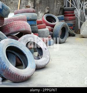 Un'immagine di molti vecchi pneumatici usati lasciati in una discarica Foto Stock