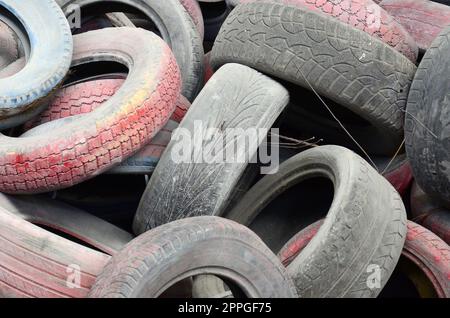 Un'immagine di molti vecchi pneumatici usati lasciati in una discarica Foto Stock