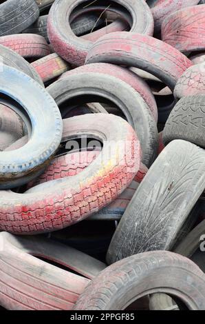 Un'immagine di molti vecchi pneumatici usati lasciati in una discarica Foto Stock