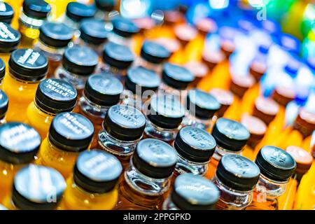 Bottiglie di bevande messe in vendita in un frigorifero commerciale Foto Stock