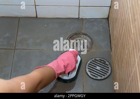 Donna che pulisce il pavimento del bagno Foto Stock