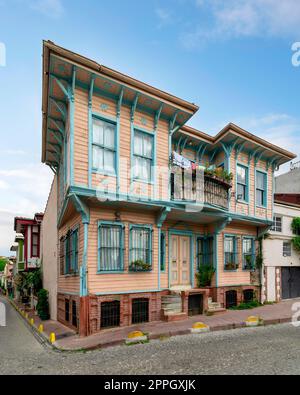 Vecchio e colorato edificio residenziale in legno con porta, finestre in ferro battuto, balcone e piante da arrampicata, Istanbul, Turchia Foto Stock