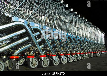 Vista obliqua della fila di carrelli della spesa messi insieme in attesa di clienti in supermercato Foto Stock
