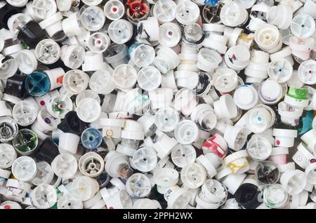 Un modello di molti impiegati e sporco ugelli da bombolette spray con bomboletta di vernice spray. Texture di sfondo della street art di disegnare graffiti sulle pareti Foto Stock