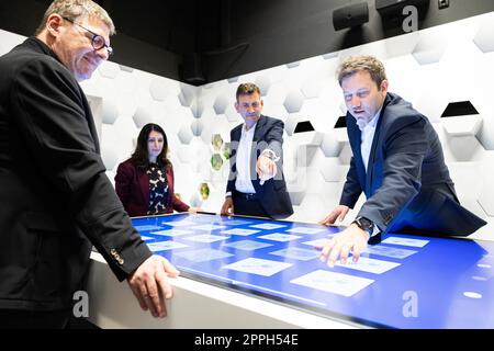 24 aprile 2023, bassa Sassonia, Wolfsburg: Ralph Linde (l-r), Capo dell'Accademia del Gruppo Volkswagen, Daniela Cavallo, Presidente del Consiglio Generale e del Consiglio di Amministrazione di Volkswagen AG, Gunnar Kilian, membro del Consiglio di Amministrazione di Volkswagen AG responsabile delle risorse umane; E Lars Klingbeil, presidente del Partito socialdemocratico tedesco (SPD), si trova a un tavolo touchscreen nella "eMotionRoom" dello stabilimento principale della Volkswagen. La "eMotionRoom" si basa sul principio di una Escape Room ed è un programma di formazione avanzato offerto dalla Volkswagen AG per formare i dipendenti nel campo dell'elettromobilità Foto Stock