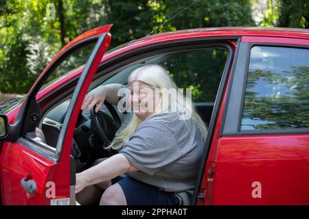 Donna che esce da un'auto parcheggiata Foto Stock