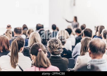 Oratore femminile che parla a una riunione d'affari. Pubblico nella sala conferenze. Simposio imprenditoriale e imprenditoriale. Foto Stock