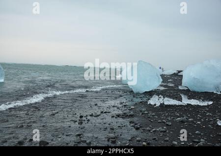 Pezzi di ghiaccio cristallini sulla sabbia nera della spiaggia Diamond a Fellsfjara, Jokulsarlon in Islanda Foto Stock