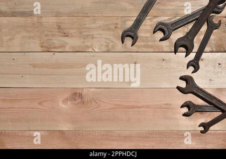 Alcune chiavi arrugginite si trovano su un tavolo di legno in un'officina Foto Stock