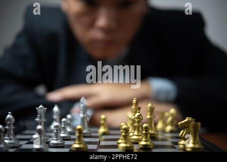 Pianificazione strategica e obiettivi successo idea di business. Uomo d'affari che guarda gli scacchi al bordo. Foto Stock