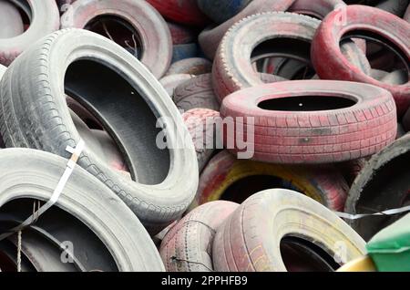 Un'immagine di molti vecchi pneumatici usati lasciati in una discarica Foto Stock