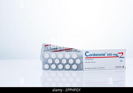 CHONBURI, THAILANDIA-23 SETTEMBRE 2022 : Cordarone in blister e scatola di carta. Prodotto Sanofi. Amiodarone pillole bianche compresse per il trattamento di aritmie. Farmaci prescritti. Farmaceutica. Foto Stock