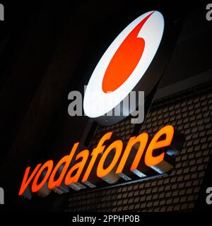 Pubblicità del fornitore di telefonia mobile Vodafone nel centro di Berlino la sera Foto Stock