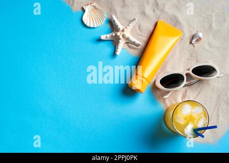 Composizione estiva con bottiglie di crema solare, stelle marine, conchiglie e occhiali da sole su sfondo blu con sabbia, spazio copia. Vacanze estive e sci Foto Stock