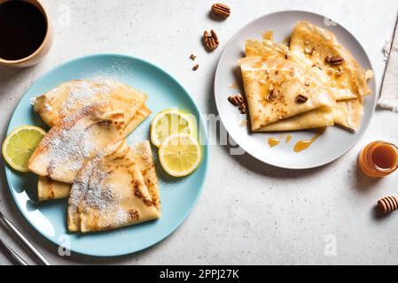 Crepes con vari condimenti - miele e noci pecan, crema di agrumi e caffè. Crepes fatti in casa per colazione o dessert. Foto Stock