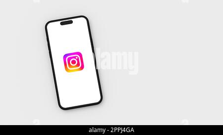 Logo Instagram sullo schermo del telefono cellulare su sfondo grigio con spazio di copia Foto Stock