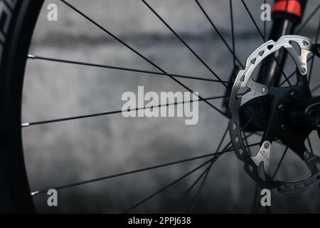 Freni idraulici a disco per bicicletta, disco in metallo grigio fissato al primo piano della ruota per bicicletta, freni efficaci e diffusi per mountain bike. Foto Stock