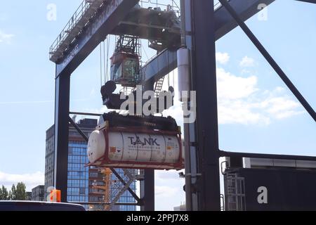 Kiel, Germania - 27.dicembre 2022: Una grande gru industriale solleva container pesanti con carico nel porto di Kiel in condizioni di sole. Foto Stock