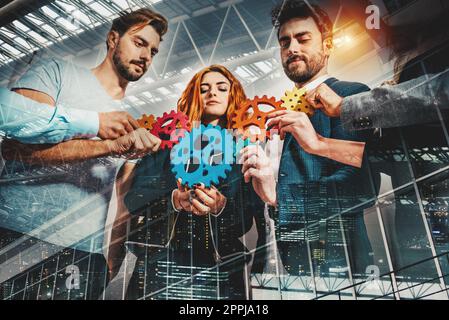 Lavoro di squadra di imprenditori lavorano insieme e combinano le parti di ingranaggi come partnership e integrazione Foto Stock