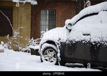 Frammento della vettura sotto uno strato di neve dopo una nevicata pesante. Il corpo della vettura è coperto di neve bianca Foto Stock