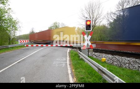 24 aprile 2023, bassa Sassonia, Neustadt am Rübenberge: Un treno passa il passaggio di livello dove un'auto è stata colpita da un treno la domenica mattina. Dopo l'incidente mortale nella regione di Hannover, la polizia sta facendo tutto il possibile per chiarire la causa. Nell'incidente, tre giovani erano morti all'inizio della domenica mattina (23.04.2023) quando la loro auto è stata colpita da un treno regionale sul passaggio di livello. Secondo la polizia, avevano guidato fino all'attraversamento del livello, nonostante le mezze barriere fossero state chiuse. Foto: Julian Stratenschulte/dpa Foto Stock