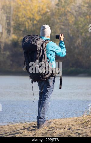 Ritratto di viaggiatore uomo al lago in autunno Foto Stock