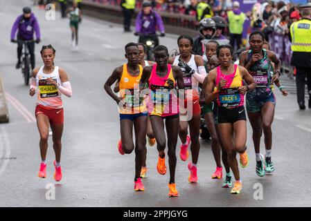 Le principali atlete d'élite che gareggiano nella TCS London Marathon 2023 passando per Tower Hill, Londra, Regno Unito, dietro i pacemaker Foto Stock