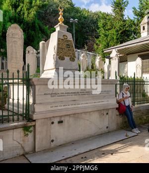 Donna in piedi accanto alla tomba di Ghazi Edhem Pasha, o Gazi Ethem Pasa, situata nella sepoltura nel cortile della Moschea del Sultano Eyup, Istanbul, Turchia Foto Stock