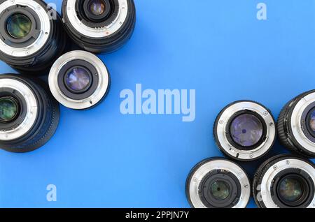 Diversi obiettivi fotografici si trovano su uno sfondo blu brillante. Spazio per il testo Foto Stock