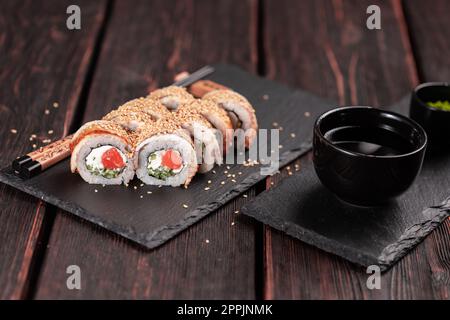 Sushi roll con anguilla affumicata e salmone con cetriolo e formaggio. Set tradizionale di panini di sushi fresco e delizioso. Menu sushi. Ristorante di cucina giapponese. Cibo asiatico Foto Stock