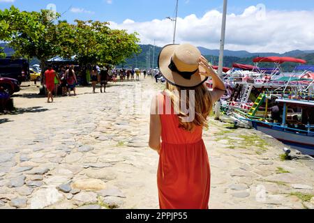 Bella donna turistica a piedi sul porto, dove viaggiare in traghetto o in barca a noleggio o yacht per esplorare le calde destinazioni tropicali Foto Stock