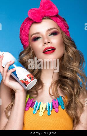 Brillante allegro ragazza in home hat, colorati per il make-up, riccioli e rosa manicure. Bellezza viso. Foto Stock