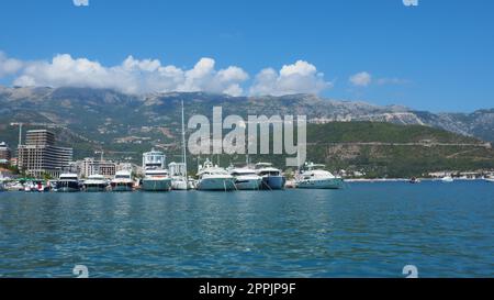 Budva, Montenegro, 15 2022 agosto mare Adriatico, costa, montagne, ondulazioni del mare. Barche e navi sono ormeggiate al terrapieno. Parcheggio per il trasporto acquatico. Foto Stock