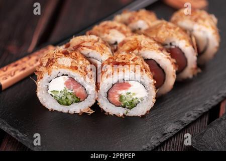 Rotolo di sushi di salmone con scaglie di tonno primo piano - menu di sushi asiatico e piatti giapponesi Foto Stock