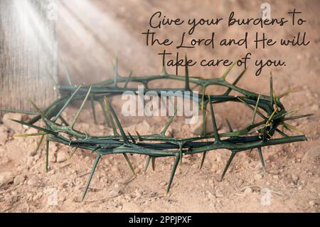 Citazione del versetto della Bibbia - dai il tuo peso al Signore e si prenderà cura di te. Con sfondo corona luminosa di spine. Foto Stock