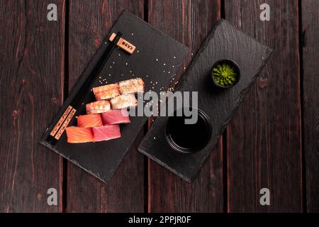 Panini con pesce salmone e gamberi e tonno maguro anguilla sushi con bacchette vista dall'alto - cucina asiatica e giapponese concetto Foto Stock