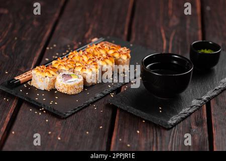 Sushi roll con tonno affumicato con avocado e formaggio. Tradizionale e delizioso sushi a rotolo fresco. Menu sushi. Ristorante di cucina Giapponese. Cibo asiatico Foto Stock