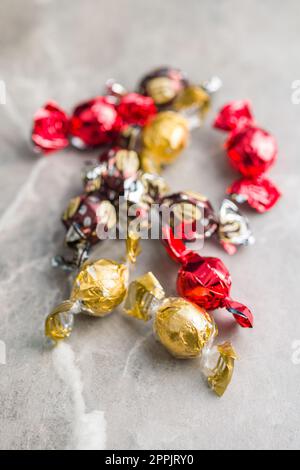 Caramelle dolci avvolte in un foglio di alluminio sul tavolo da cucina. Foto Stock