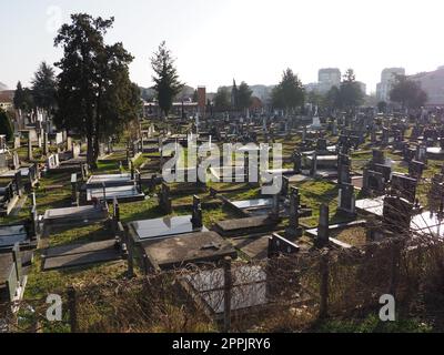 Sremska Mitrovica, Serbia, 25 febbraio 2021. Cimitero moderno della città cristiana. Tombe con monumenti in pietra e croci. Lapidi di granito. Cripta o cappella. Tema funerale o Halloween Foto Stock