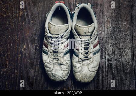 Dirty old scarpe sul pavimento in legno Foto Stock