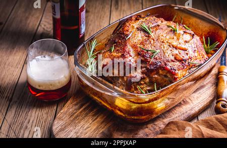 Carne di maiale arrostita con patate, rosmarino e salsa alla birra Foto Stock