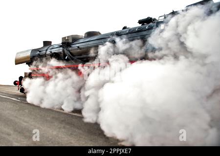 Una locomotiva a vapore emette fumo e vapore alla massima velocità Foto Stock